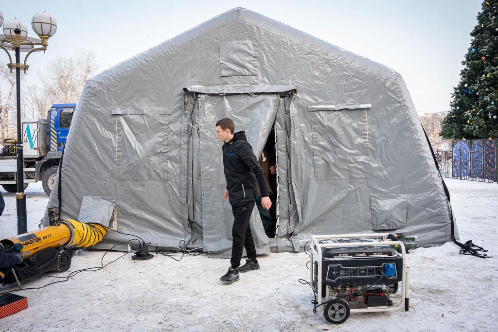 乌克兰东北部波里斯皮尔市的居民正在利用供暖点取暖。