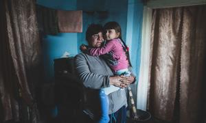 Una mujer sostiene a su hija en brazos en su casa, situada justo en la "línea de contacto" en Ucrania (foto de archivo). 