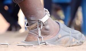 Un primer plano del tobillo de un detenido con una cadena de metal y esposas, que simboliza la llegada de la justicia a través de un tribunal móvil en Sudán del Sur.