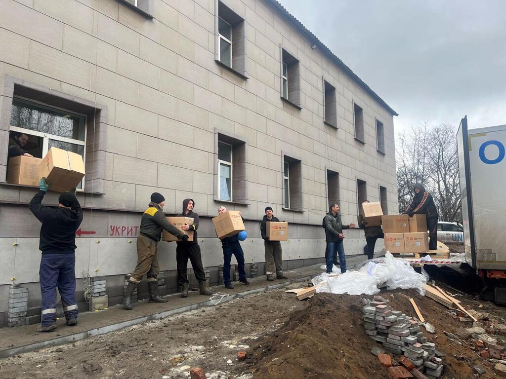 Humanitarian workers unload boxes of aid supplies to distribute to residents in Dobropillia, Ukraine.