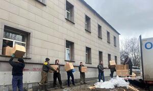 Humanitarian workers unload boxes of aid supplies from a truck to distribute to residents in Dobropillia, Ukraine.
