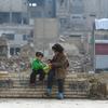 أطفال يجلسون على جدار في دوما في سوريا.