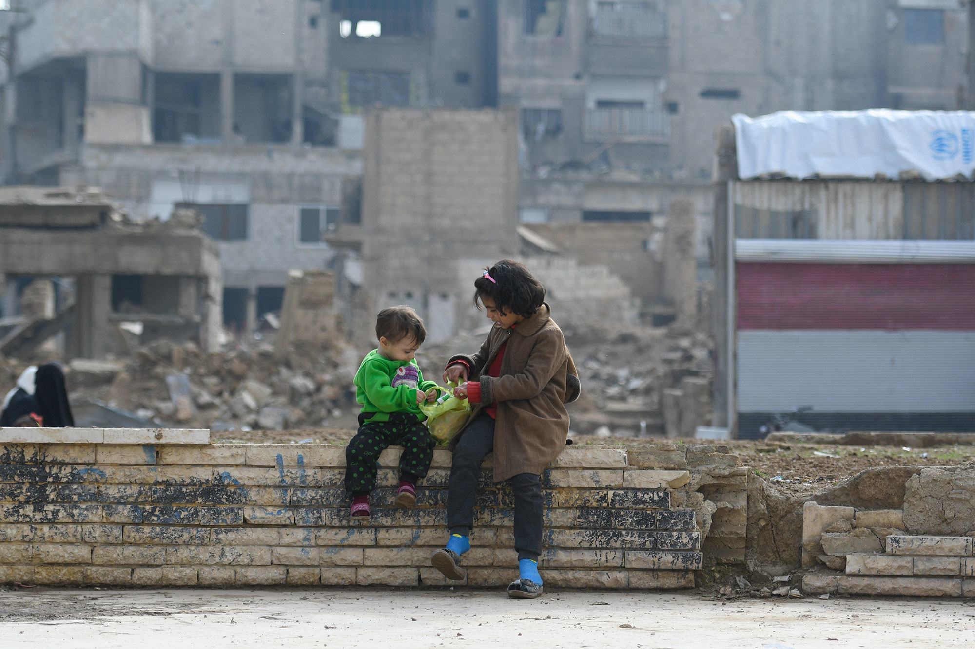 طفلان يجلسان على جدار في دوما في سوريا.