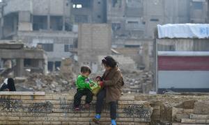 Children sit on a wall in Douma in Syria.