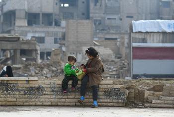 أطفال يجلسون على جدار في دوما في سوريا.