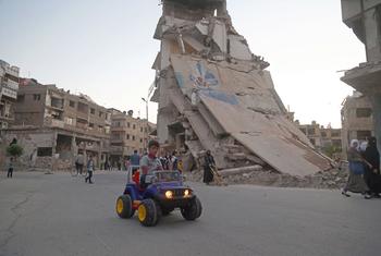 Un niño conduce su coche de juguete mientras la gente celebra el Eid al-Fitr, en Ghouta oriental  (Siria).