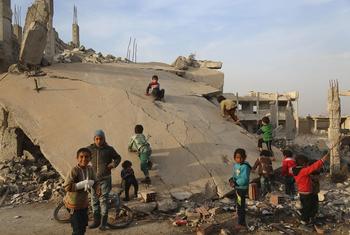 सीरिया के पूर्वी ग़ूता इलाक़े में एक ध्वस्त इमारत के पास बच्चे खेलते हुए.