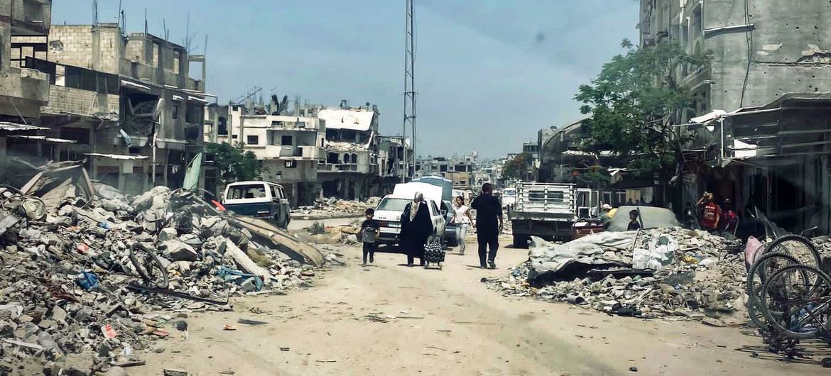 Una familia palestina camina entre las ruinas de un barrio bombardeado en Gaza.