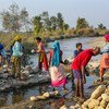 Women build barriers in Nepal to prevent the river from overflowing and flooding nearby villages.
