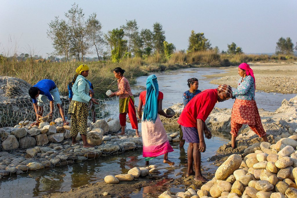 Women build barriers in Nepal to prevent the river from overflowing and flooding nearby villages.