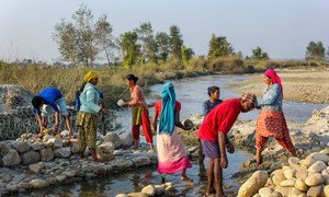 Women build barriers in Nepal to prevent the river from overflowing and flooding nearby villages.