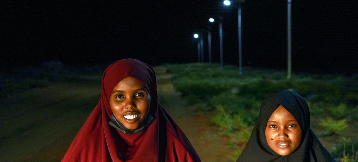 Iftin and Aminaa stand near the solar lights that now allow dozens of girls to walk safely to evening classes. Iftin and Aminaa stand near the solar lights that now allow dozens of girls to walk safely to evening classes.