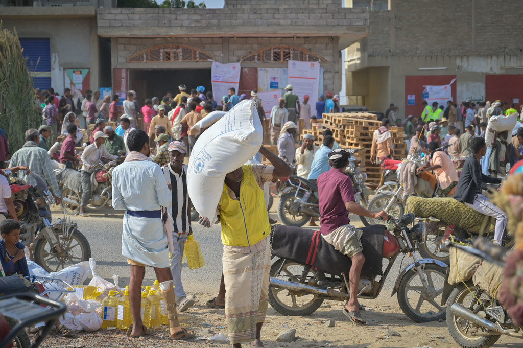 Des habitants du district d'Aslam, dans l'ouest du Yémen, collectent de la nourriture dans un point de distribution du Programme alimentaire mondial (PAM).