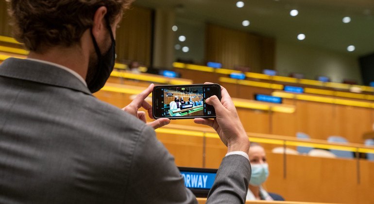 As the prime Minister of Norway, addresses the general debate, a delegate takes a photo of the country's position in the General Assembly hall.