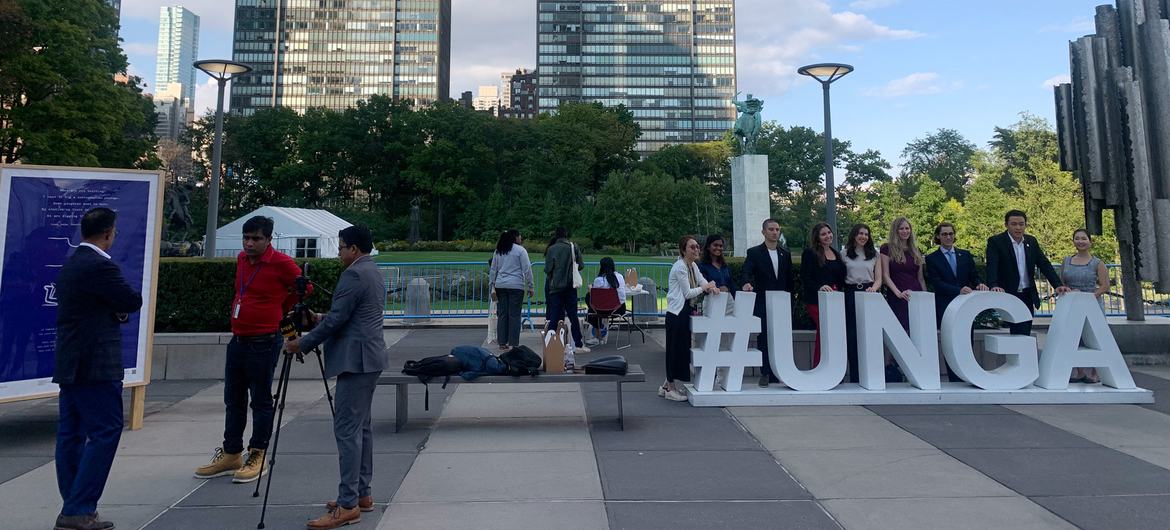 الناس يتخذون وضعيات لالتقاط الصور أمام لافتة كبيرة تحمل شعار #UNGA في قمة المستقبل التي أقيمت في مقر United Nations في نيويورك.