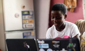 A child in Ghana works at a computer.