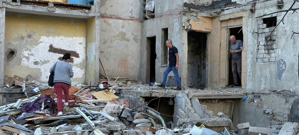 People survey the damage caused by a missile attack on a building in Kharkiv City, Ukraine.