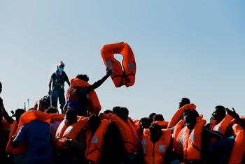Rescued migrants aboard a boat after being saved from a capsized vessel during a perilous sea crossing.