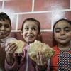 Children sheltering at an UNRWA school in Gaza enjoy bread distributed by WFP.