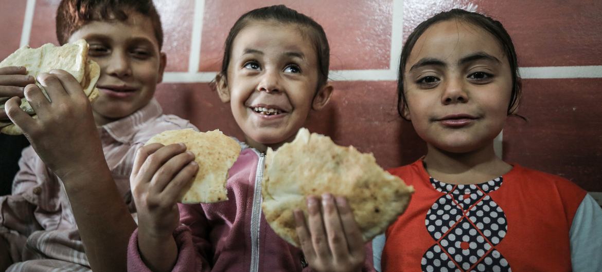 مقبوضہ فلسطینی علاقوں میں اقوام متحدہ کے امدادی ادارے ’انرا‘ کے ایک سکول میں پناہ لیے بچے ڈبیلو ایف پی کی طرف سے تقسیم کیا گیا کھانا کھاتے ہوئے۔