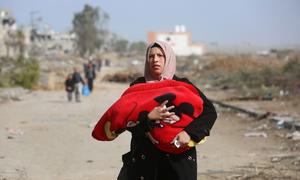 A woman flees the Al Zeitoun neighborhood in Gaza City to the south of the Gaza Strip.