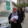 Una mujer lleva el cuerpo de un recién nacido que murió en un ataque contra el hospital Nasser de Khan Younis, Gaza (archivo).