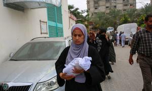 Una mujer lleva el cuerpo de un recién nacido que murió en un ataque contra el hospital Nasser de Khan Younis, Gaza (archivo).