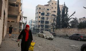 A woman walks next to her destroyed house in the Palestine Stadium area in central Gaza City. (file)