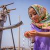 Une fillette de six ans boit de l'eau d'une pompe à main communautaire au Pakistan.