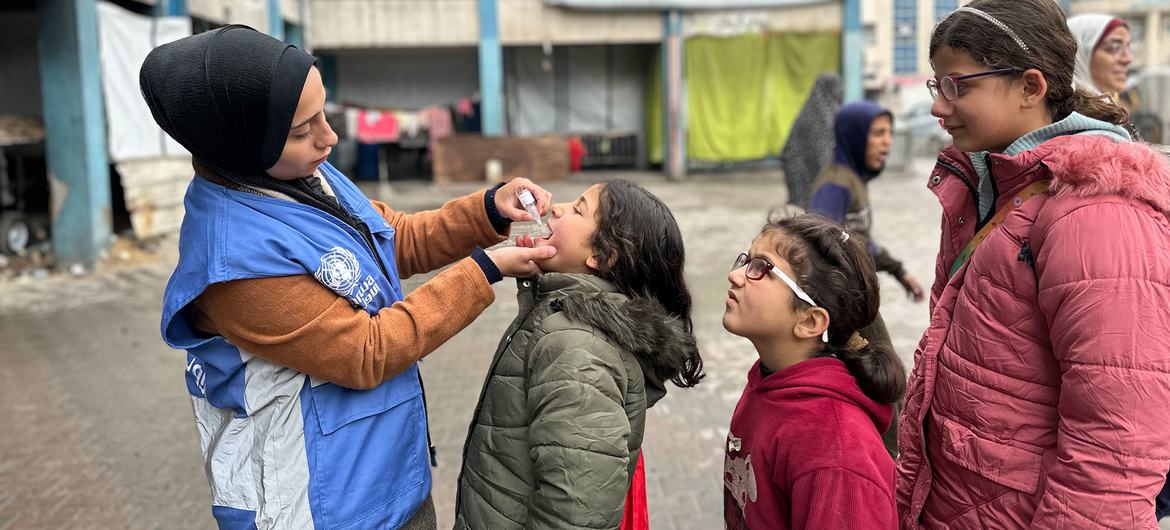 Une employée de l'ONU administre un vaccin contre la polio à des enfants à Gaza, en février 2025.