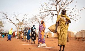 Refugees practice physical distancing that have been put in place at a camp in South Sudan, where rations have been increased to reduce the number of times large groups need to gather to receive humanitarian aid.