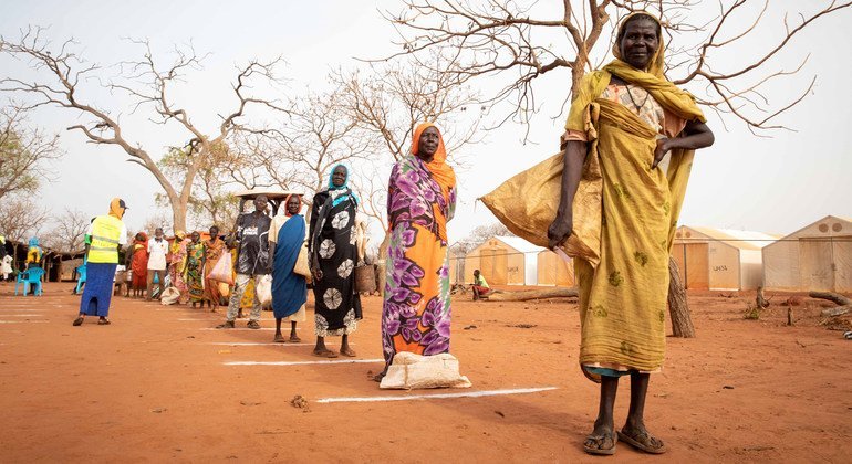 Refugees practice physical distancing that have been put in place at a camp in South Sudan, where rations have been increased to reduce the number of times large groups need to gather to receive humanitarian aid.