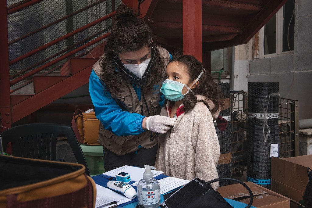 طفلة في السابعة من العمر تتلقى فحصا طبيا في أحد المواقع التي تسكن بها في روما، والطبيبة التي تقدم لها خدمة الفحص ضمن عمل فريق المساعدة التابع لليونيسف