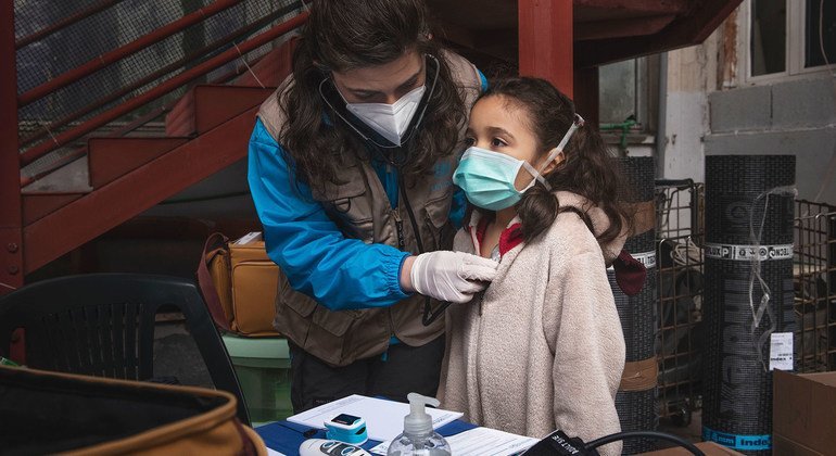 A doctor performs a medical check on a young girl in an informal settlement in Rome, Italy. 