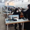Des réfugiés à Sarvestan, en Iran, participent à un atelier de couture mis en place par le PAM pour fabriquer des masques.