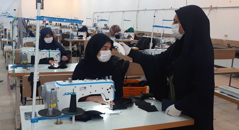 Des réfugiés à Sarvestan, en Iran, participent à un atelier de couture mis en place par le PAM pour fabriquer des masques.