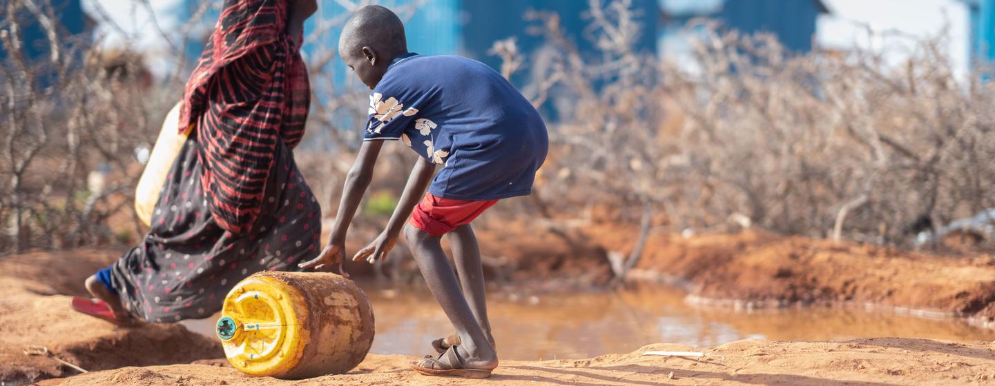 Мальчик катит емкость с водой в Доллоу у границы Сомали с Эфиопией. Мальчик катит емкость с водой в Доллоу у границы Сомали с Эфиопией.