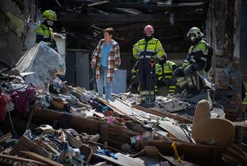 Des secouristes fouillent les décombres d'un immeuble bombardé à Kyïv, en Ukraine.