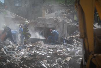 Rescue workers search through the rubble of a destroyed building following the 24 April 2025 strike in Kyiv, Ukraine.