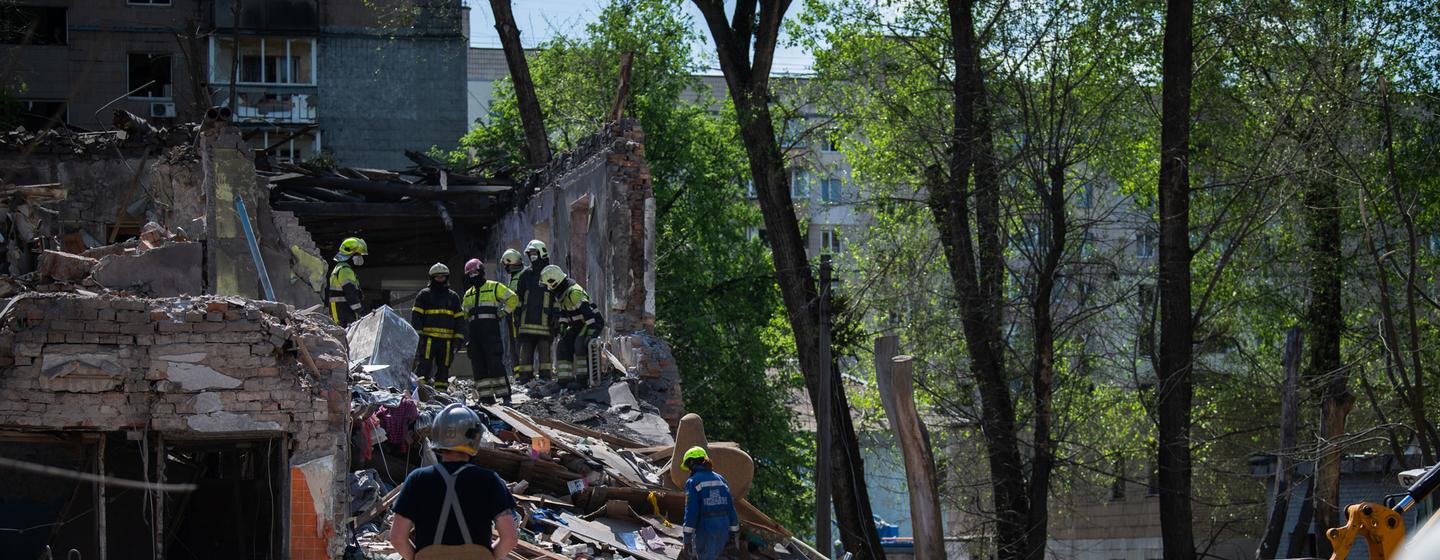 Des secouristes fouillent les décombres d’un bâtiment bombardé à Kyiv, en Ukraine.