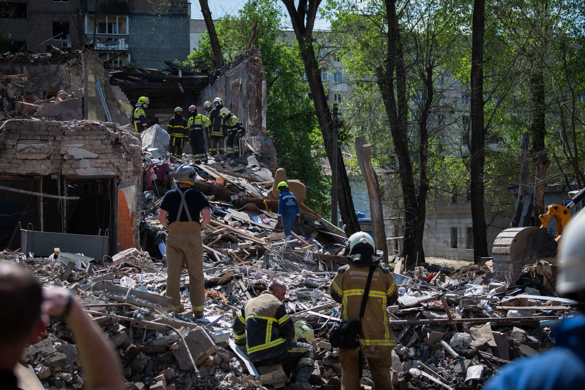 Des secouristes fouillent les décombres d’un bâtiment bombardé à Kiev, en Ukraine.