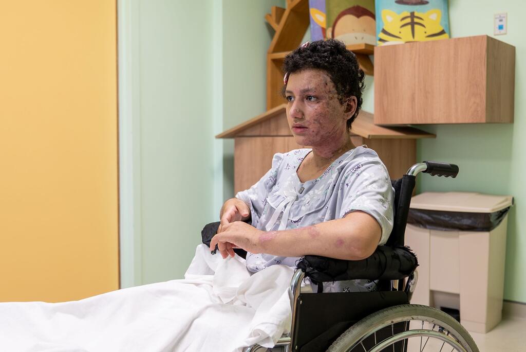 Kawthar, 14 ans, patiente d'un hôpital à Beyrouth, au Liban, est assise dans un fauteuil roulant, montrant des blessures visibles causées par des éclats d'obus et des blessures au visage subies lors de l'escalade à Baalbeck le 5 mars 2026. Elle se remet de ses blessures dans le cadre du programme ACWA de l'UNICEF.
