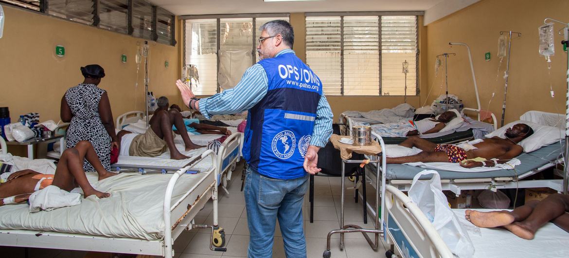 Dr. Oscar Barreneche of PAHO meets with a patient at La Paix University Hospital, in Port-au-Prince.