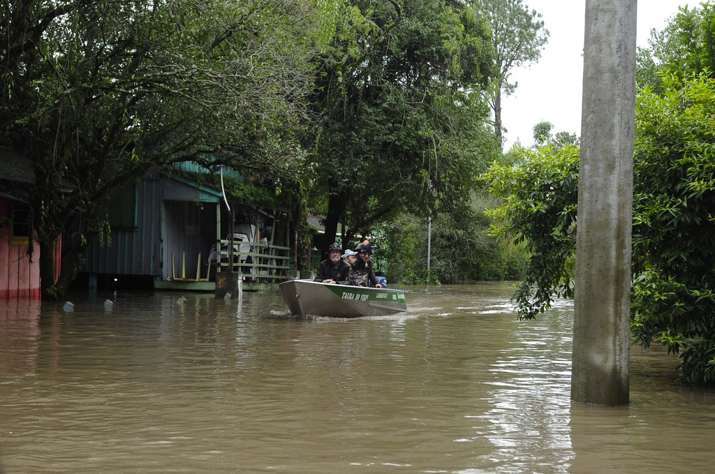 Personal de la OIM a bordo de una lancha de rescate navega entre las aguas de la inundación en Rio Grande do Sul, Brasil, para ayudar a las familias desplazadas.