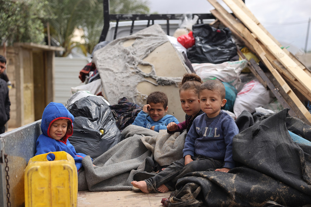 Niños sentados en la parte trasera de un camión mientras las familias se ven desplazadas de nuevo por la guerra en Gaza.