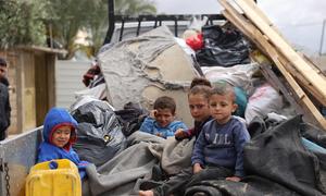 Niños sentados en la parte trasera de un camión mientras las familias se ven desplazadas de nuevo por la guerra en Gaza.