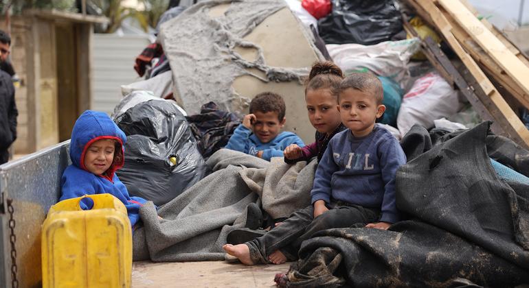 Des enfants de Gaza assis à l'arrière d'un camion, alors que leurs familles sont à nouveau déplacées par la guerre.