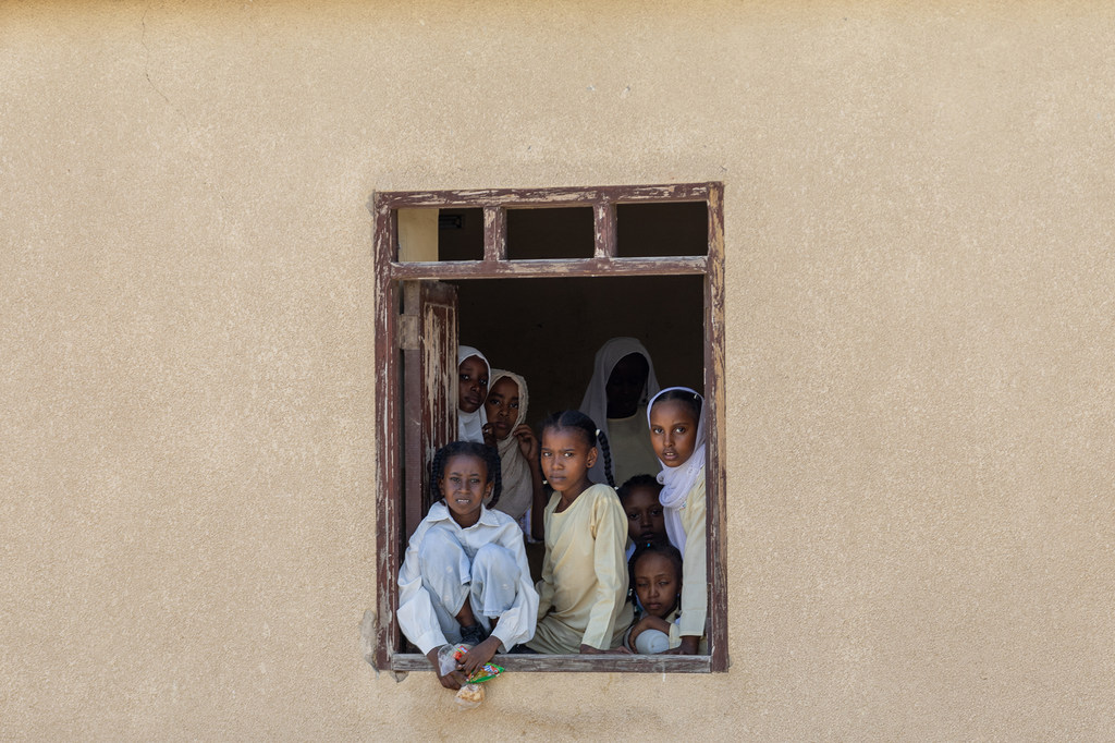 A group of children look out of the window of a school in Port Sudan.