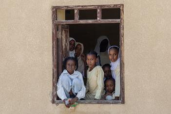 A group of children look out of the window of a school in Port Sudan.