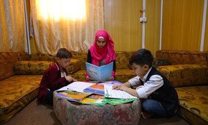 في مخيم للاجئين في الأردن، تساعد مراهقة سورية شقيقها الأصغر وابن جارها على الدراسة خلال جائحة كوفيد-19.